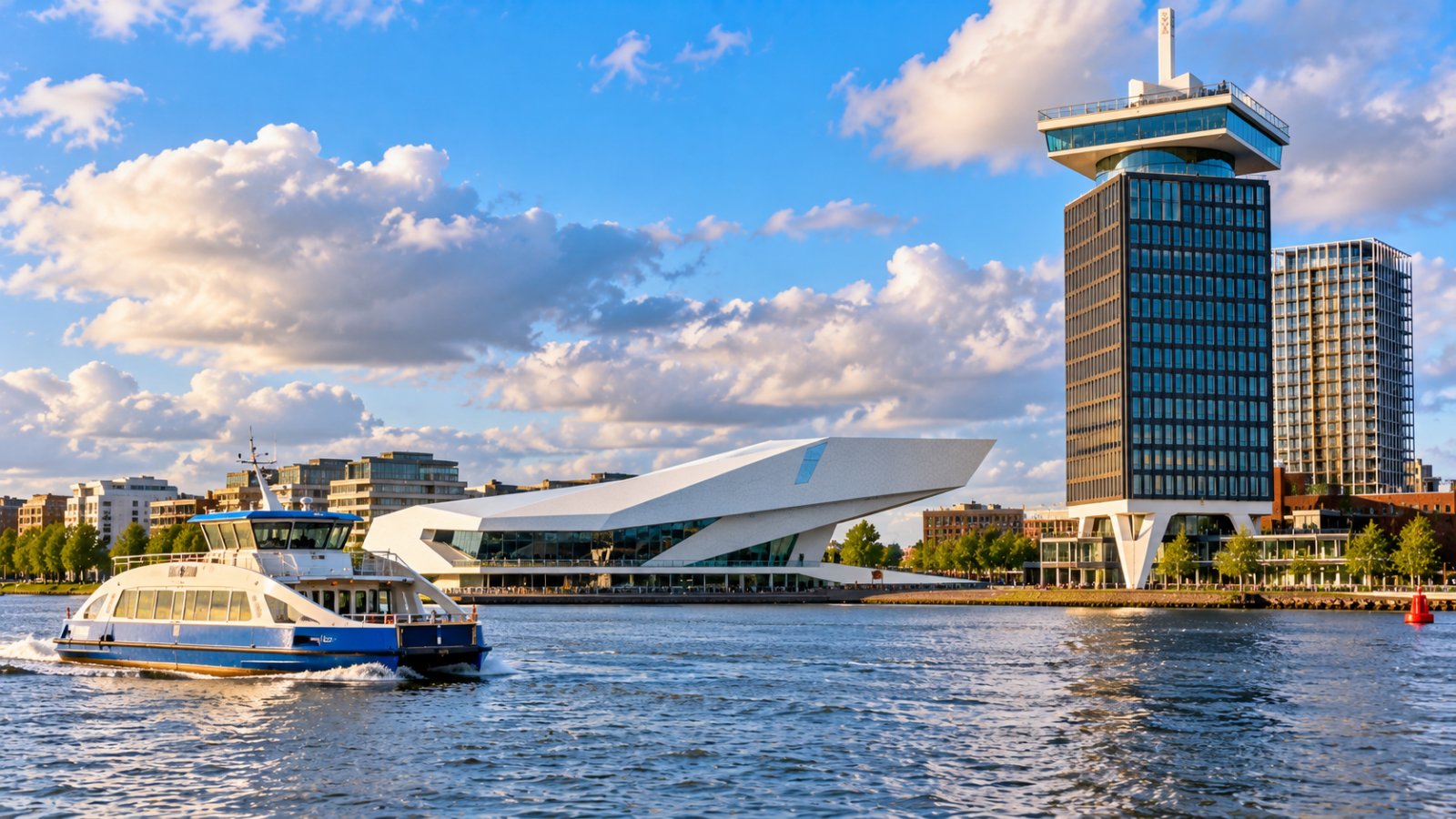 Il fiume IJ ad Amsterdam con un traghetto e l'edificio bianco e spigoloso di un museo del cinema sulla riva nord, sotto un cielo con nuvole