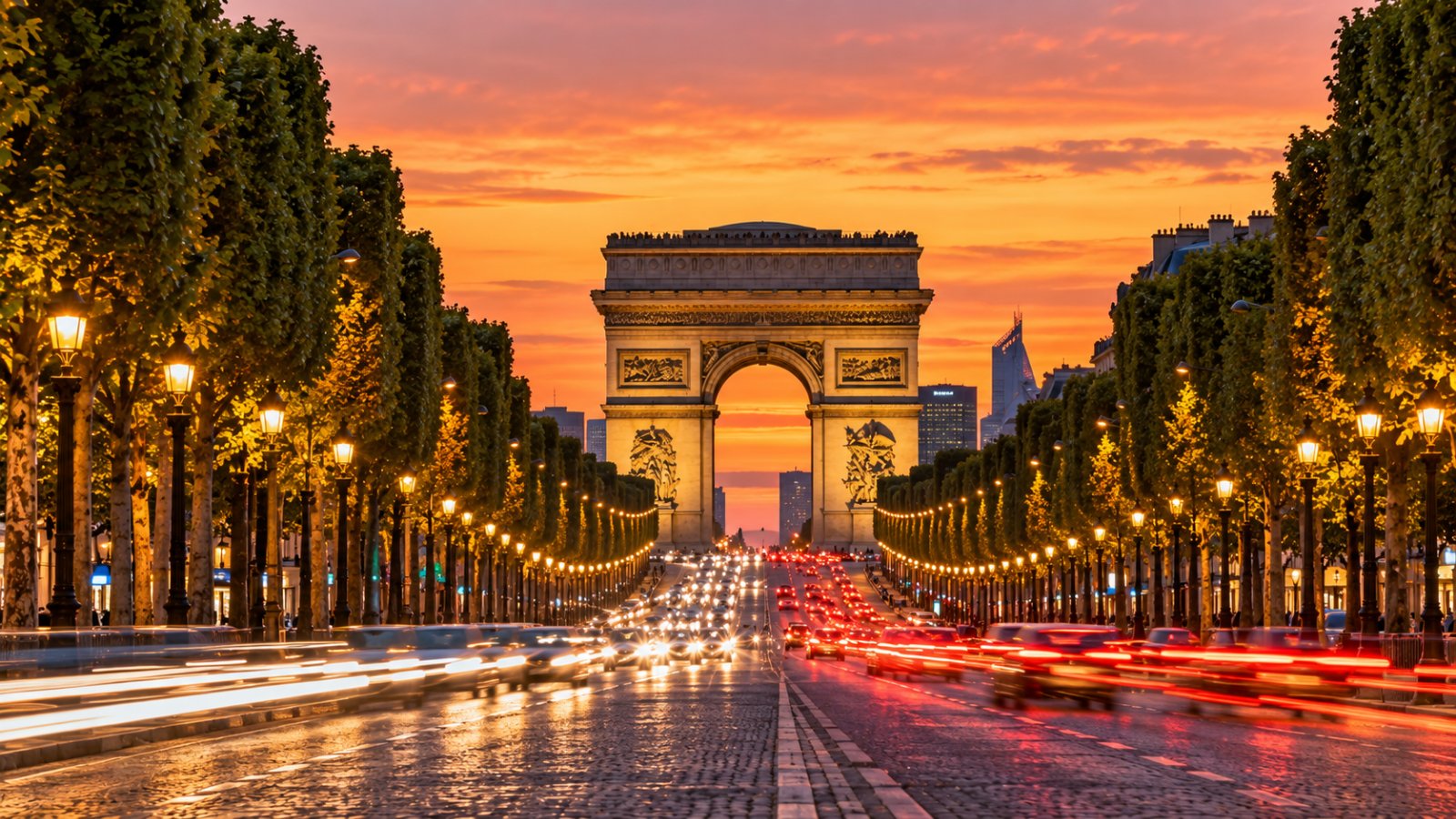 L'Arco di Trionfo in fondo al viale degli Champs-Élysées al tramonto, con i lampioni accesi e gli alberi lungo il viale