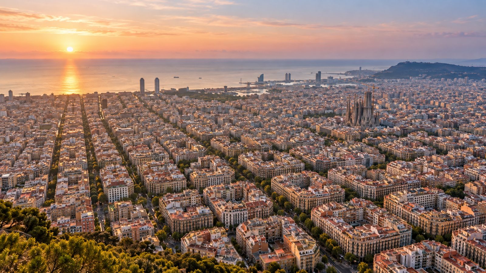 Veduta di Barcellona all'alba, con gli isolati dell'Eixample e il mare sullo sfondo