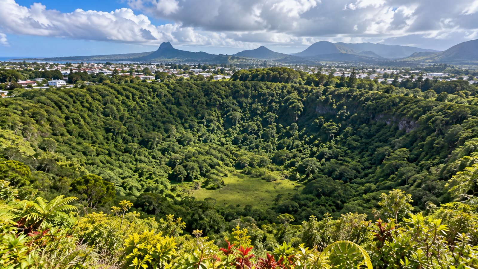 Il cratere spento del Trou aux Cerfs a Curepipe, una conca verde coperta di vegetazione con le case e le montagne dell'altopiano di Mauritius tutto intorno