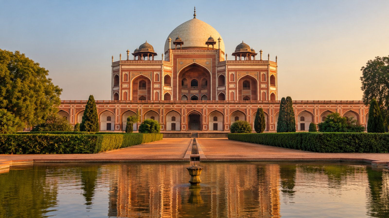 La Tomba di Humayun a Delhi, in arenaria rossa con la cupola di marmo bianco, vista dal giardino con i canali d'acqua nella luce calda del pomeriggio