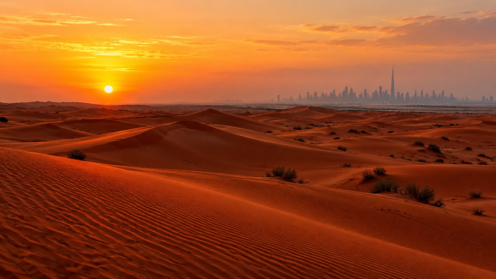 Le dune rosse del deserto degli Emirati al tramonto, con lo skyline di Dubai all'orizzonte
