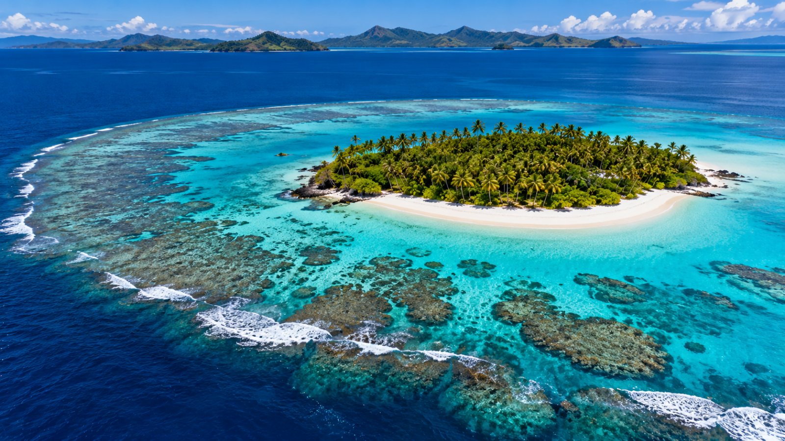 Un isolotto delle Fiji circondato da sabbia bianca e da una laguna turchese, visto dall'alto