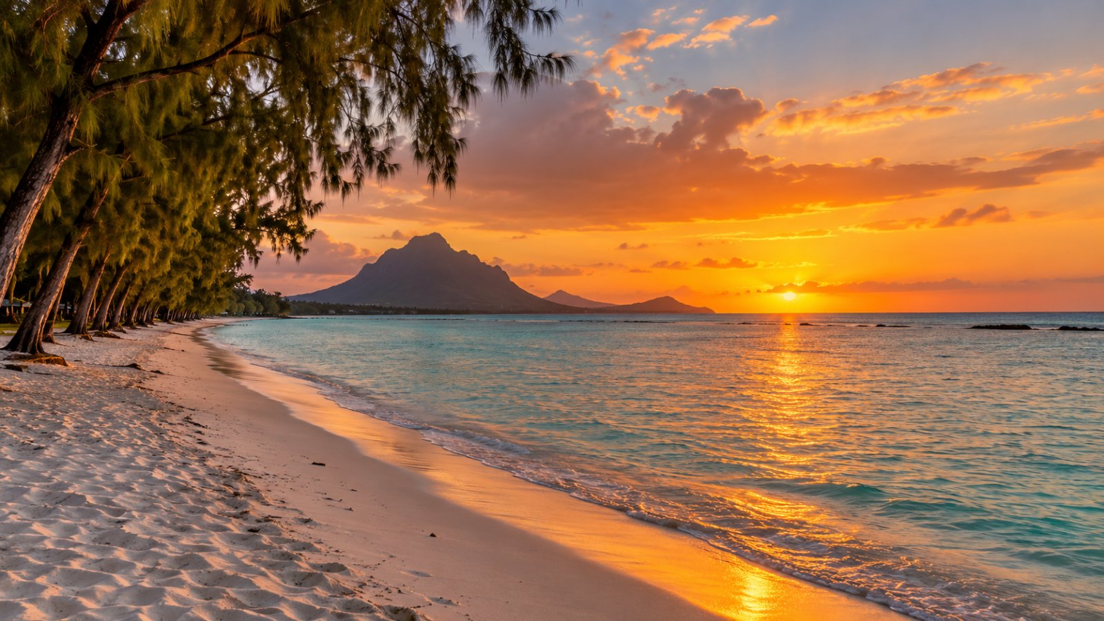 La lunga spiaggia di Flic en Flac al tramonto, con la sabbia bianca, le casuarine e la laguna calma sulla costa ovest di Mauritius
