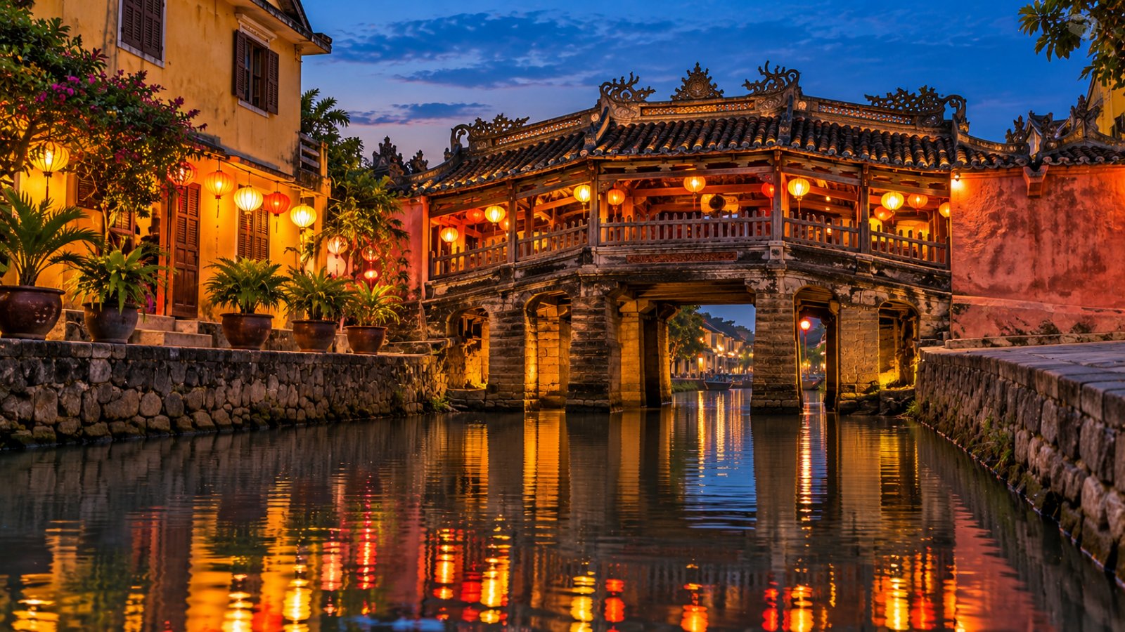 Il Ponte giapponese coperto di Hoi An al crepuscolo, con le lanterne colorate accese che si riflettono nell'acqua del canale