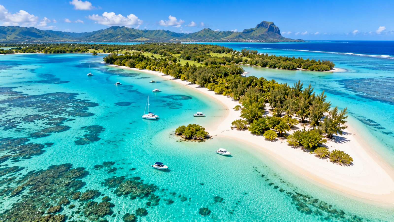 Una lingua di sabbia bianca dell'Isola dei Cervi tra la vegetazione tropicale e la laguna turchese, con alcune barche ancorate nell'acqua bassa