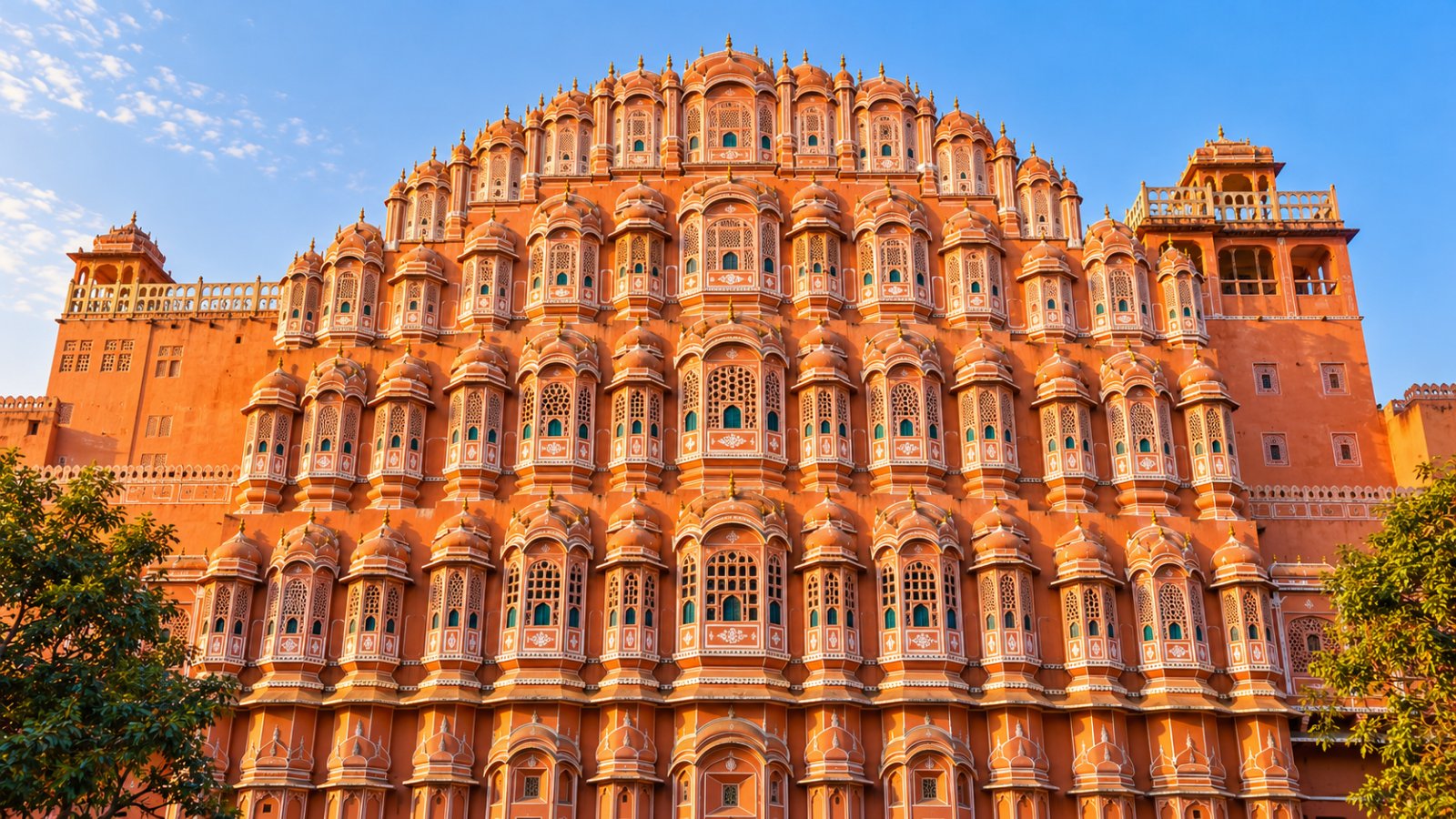 La facciata rosa dell'Hawa Mahal a Jaipur, con le sue finestrelle a nido d'ape, nella luce calda del primo mattino