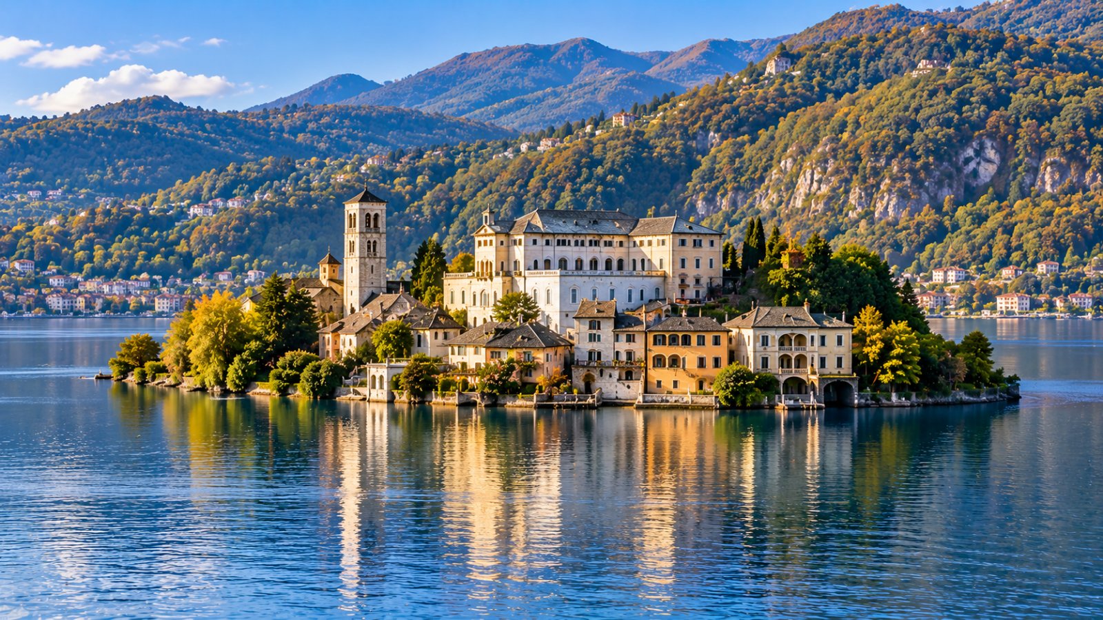 Un'isola con un campanile e un monastero in mezzo a un lago calmo circondato da colline boscose