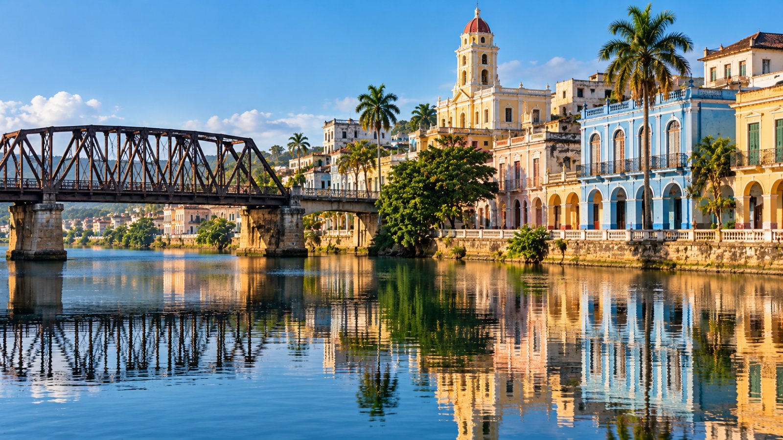 Un ponte di ferro sul fiume a Matanzas, con le case coloniali colorate e un campanile che si riflettono nell'acqua