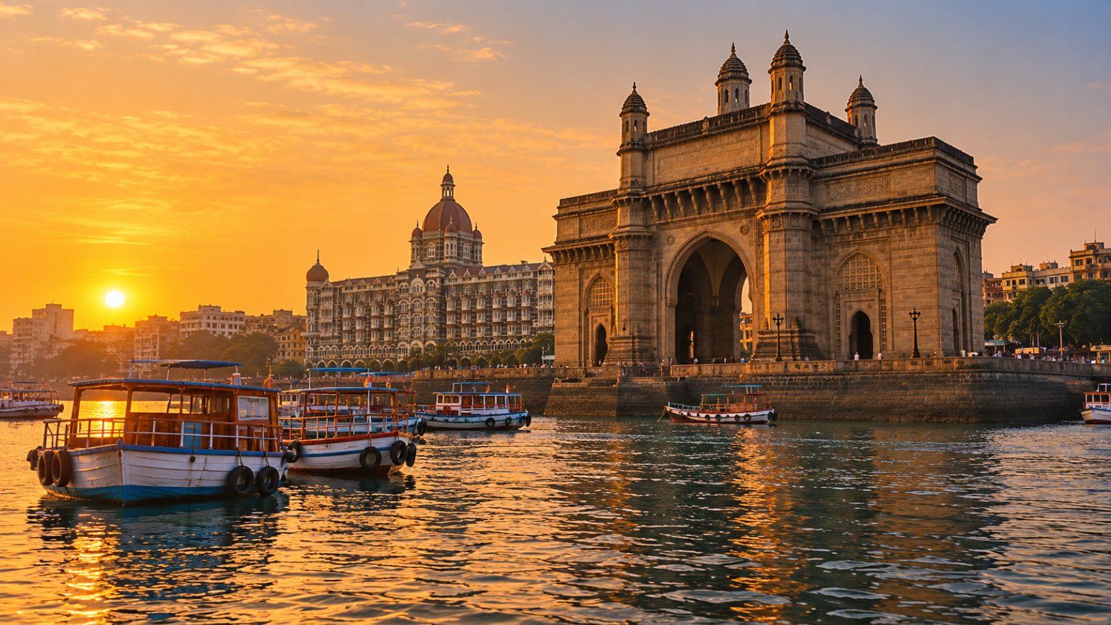 Il Gateway of India sul lungomare di Mumbai al tramonto, con le barche ormeggiate nella baia