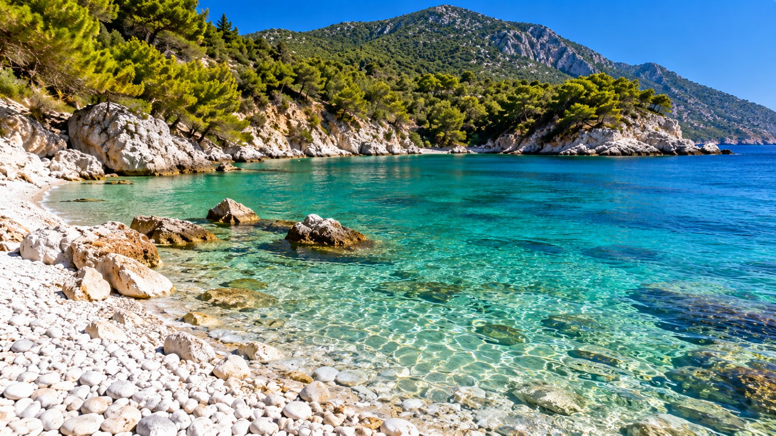 Una baia di Samos con il mare trasparente e le colline verdi coperte di pini