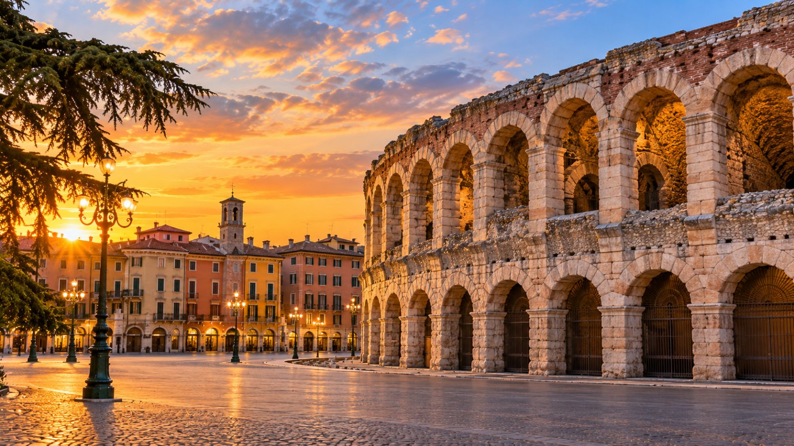 Un grande anfiteatro romano in una piazza con palazzi storici color pastello al tramonto
