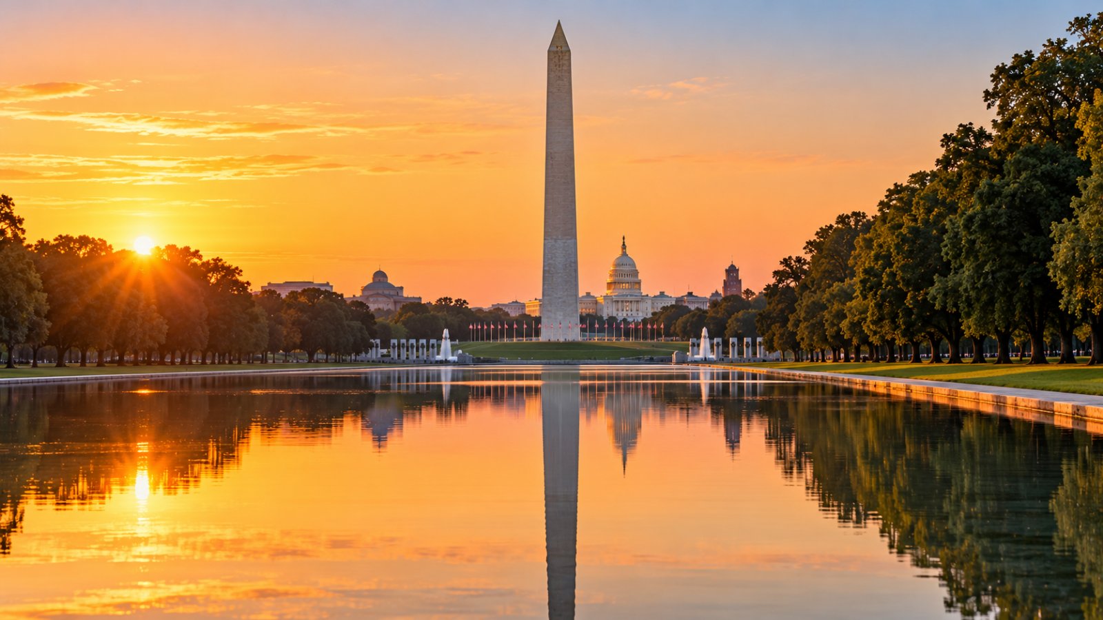 Il National Mall di Washington all'alba, con l'obelisco del Washington Monument riflesso nella lunga vasca d'acqua e la cupola del Campidoglio sullo sfondo