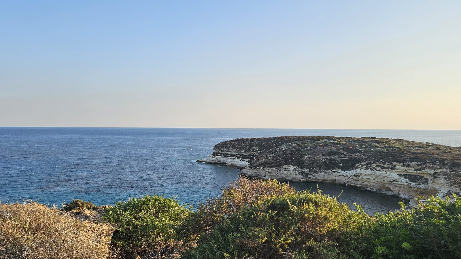 La costa di Lampedusa e il mare aperto nella luce della sera